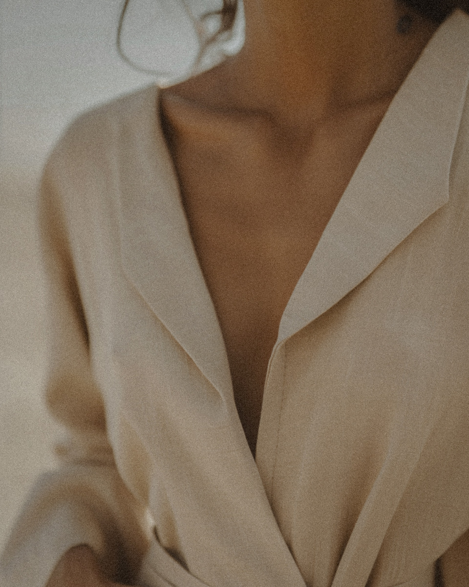 Neutral beige blazer worn over bare skin, minimalist fashion portrait