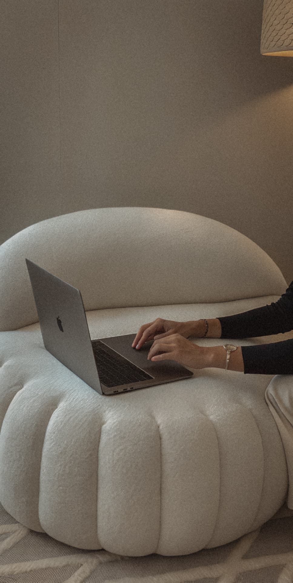 Person working on a laptop in a minimalist modern interior